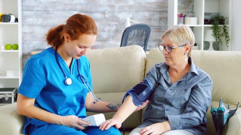 female-doctor-taking-blood-pressure-senior-woman-nursing-home-sitting-sofa_482257-20666-1